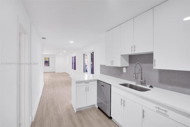 kitchen with white cabinetry, sink, stainless steel dishwasher, backsplash, and light wood-type flooring