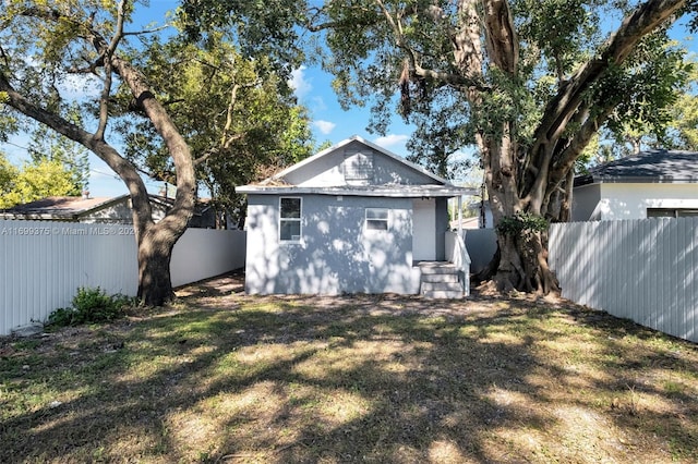 rear view of house featuring a yard