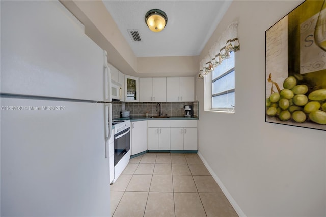 kitchen featuring white cabinetry, sink, tasteful backsplash, white appliances, and light tile patterned floors