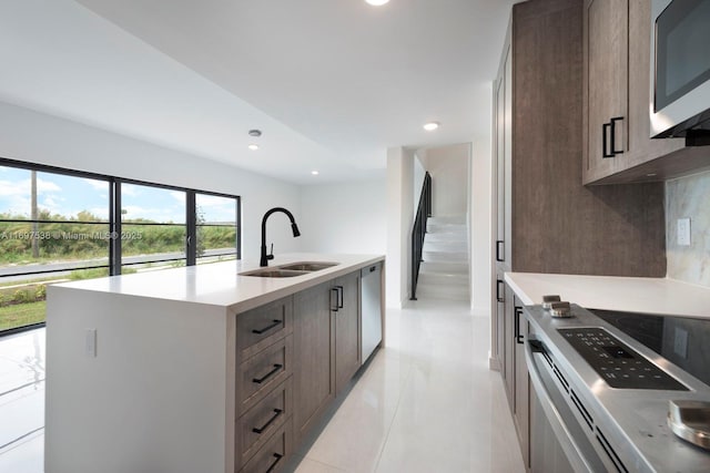 kitchen with recessed lighting, a sink, light countertops, appliances with stainless steel finishes, and backsplash