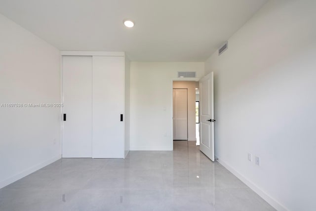 unfurnished bedroom with visible vents, baseboards, and a closet