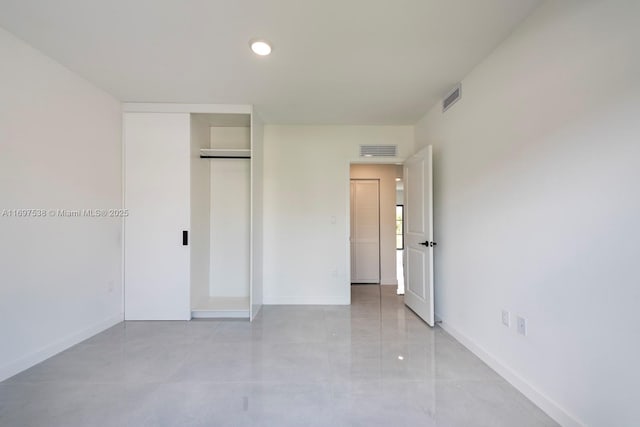 unfurnished bedroom with baseboards, visible vents, and a closet