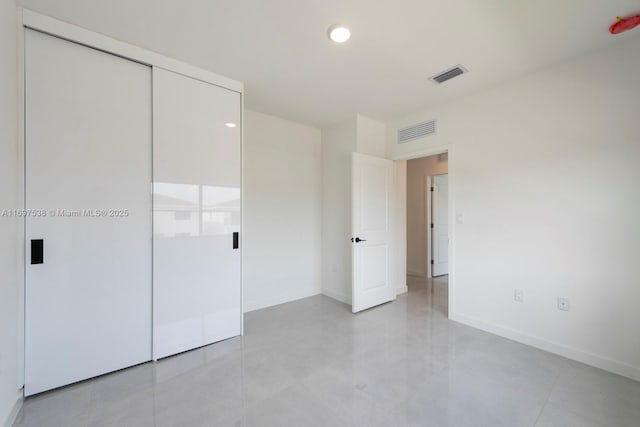 unfurnished bedroom featuring a closet, visible vents, and baseboards