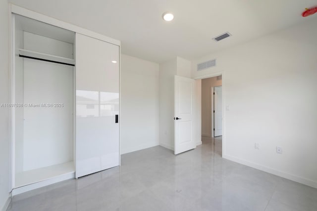 unfurnished bedroom featuring baseboards, visible vents, and a closet