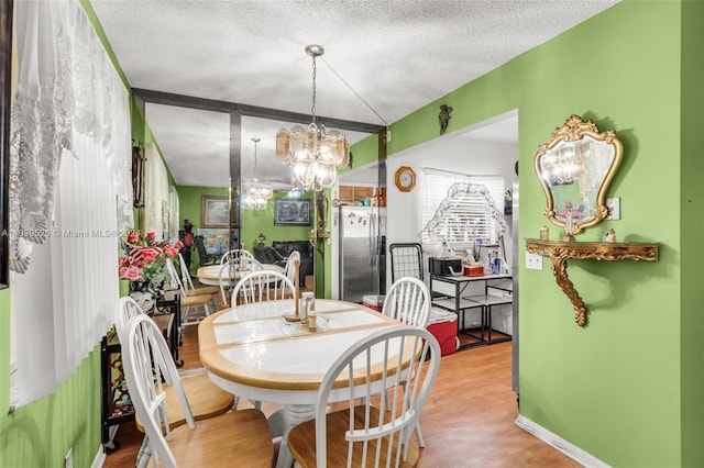 dining area featuring a chandelier, a textured ceiling, and hardwood / wood-style flooring