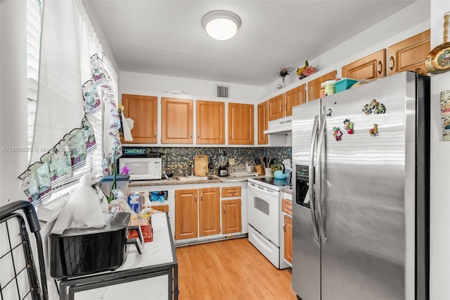 kitchen featuring tasteful backsplash, light hardwood / wood-style flooring, and white appliances