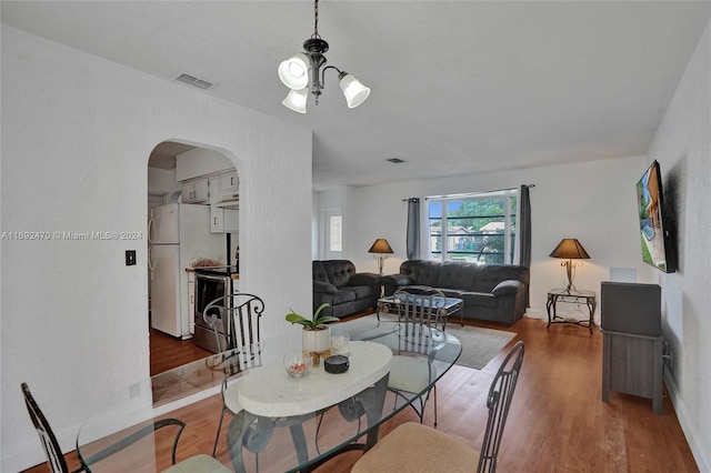 dining area featuring hardwood / wood-style flooring and a chandelier