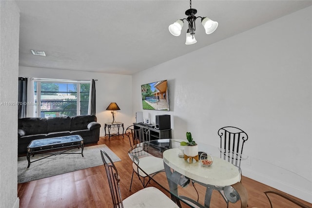 dining room with hardwood / wood-style flooring and a notable chandelier