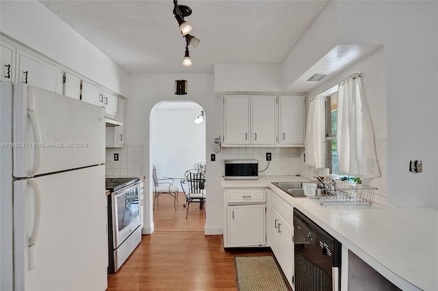 kitchen featuring white cabinets, appliances with stainless steel finishes, backsplash, and hardwood / wood-style floors