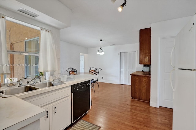 kitchen with black dishwasher, pendant lighting, white refrigerator, and plenty of natural light