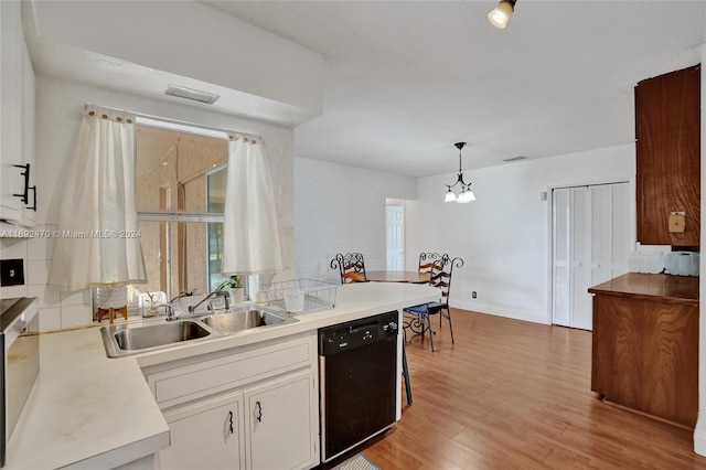 kitchen with light wood-type flooring, sink, pendant lighting, black dishwasher, and white cabinetry