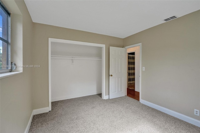 unfurnished bedroom with carpet floors and a closet