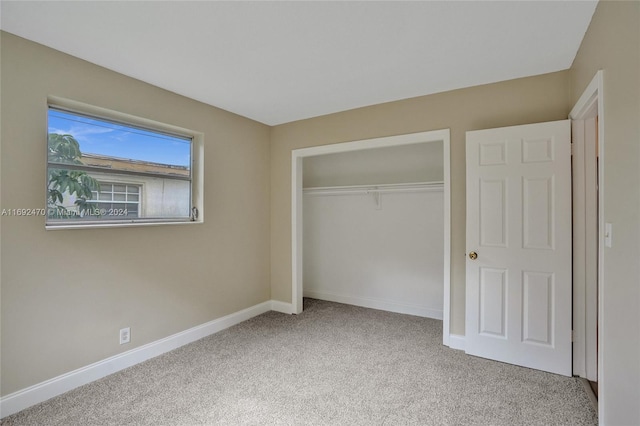 unfurnished bedroom with a closet and light colored carpet