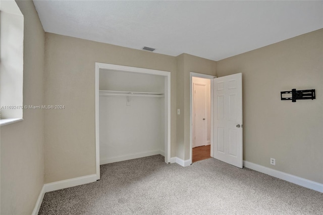 unfurnished bedroom featuring carpet floors and a closet