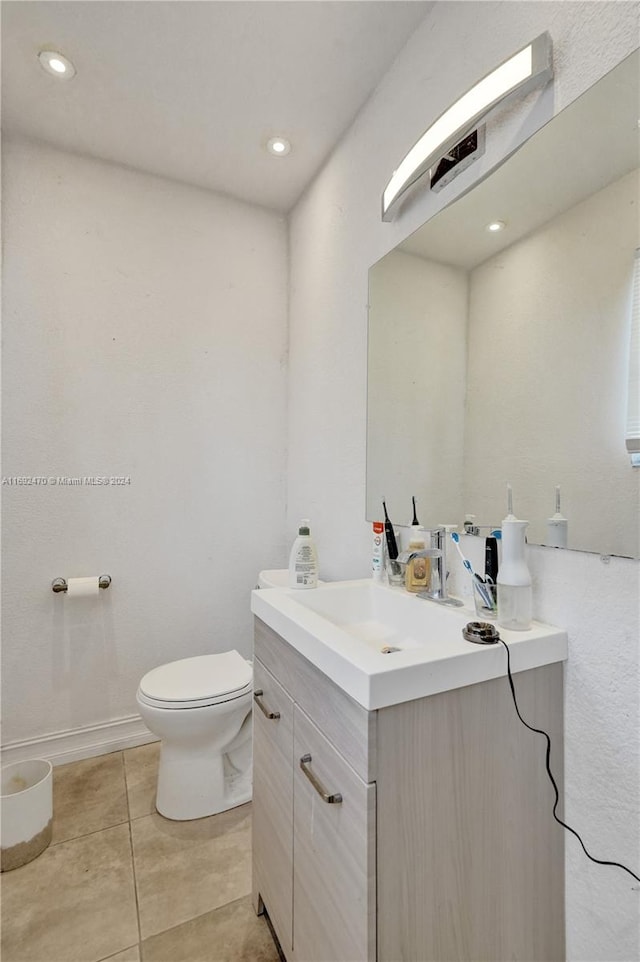 bathroom featuring tile patterned flooring, vanity, and toilet