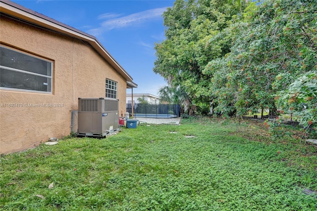 view of yard with central AC unit and a trampoline