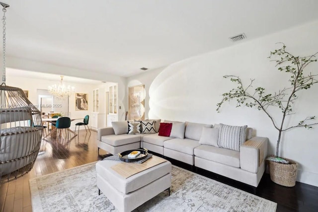 living room featuring a chandelier and wood-type flooring