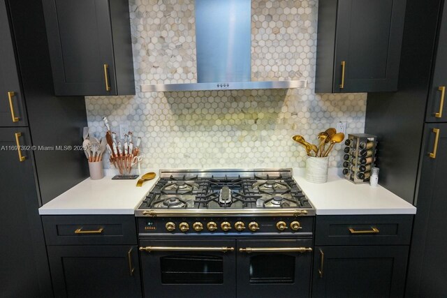 kitchen featuring tasteful backsplash, wall chimney range hood, and double oven range