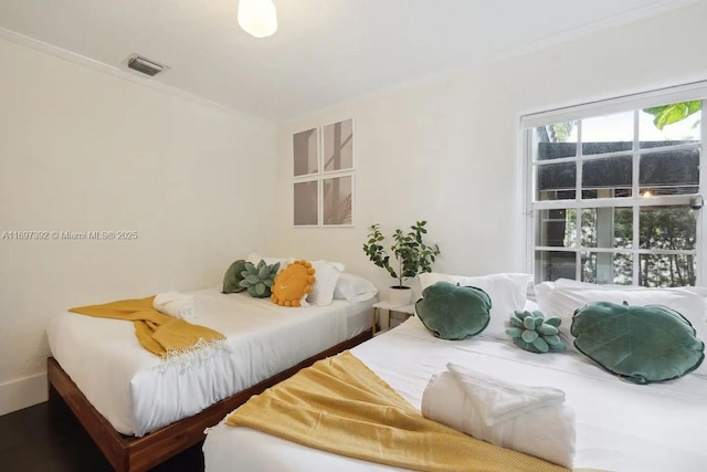 bedroom with hardwood / wood-style floors and crown molding