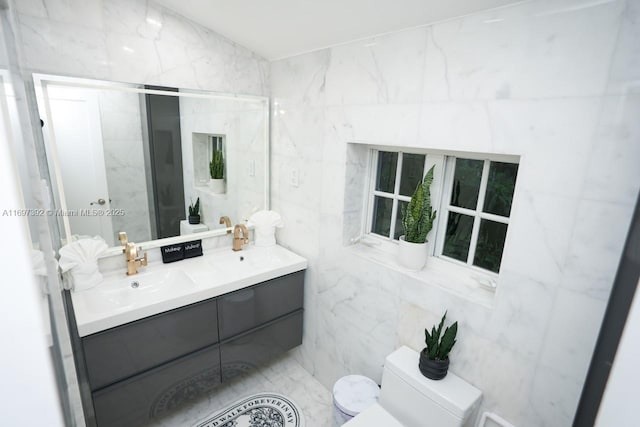 bathroom with tile walls, vanity, and toilet