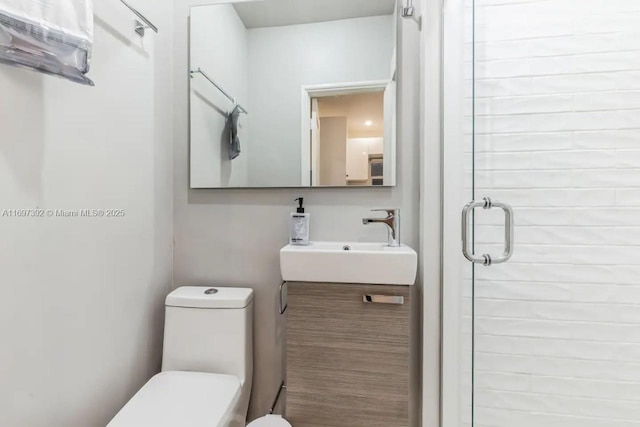 bathroom with an enclosed shower, vanity, and toilet