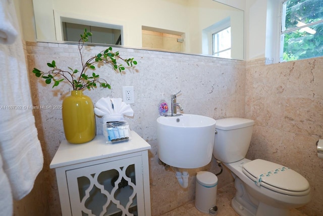 bathroom featuring tile walls and toilet