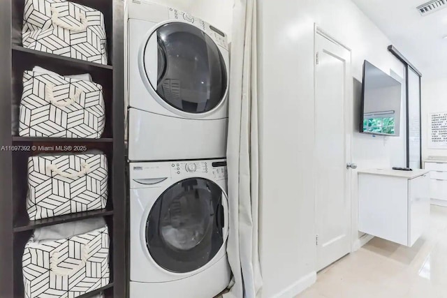 clothes washing area with stacked washer / dryer