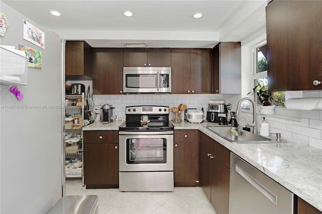 kitchen with appliances with stainless steel finishes, dark brown cabinetry, and sink