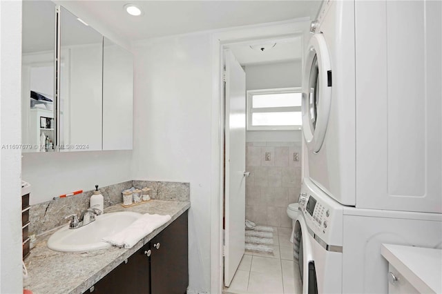 bathroom with tile patterned floors, stacked washer / drying machine, toilet, and vanity