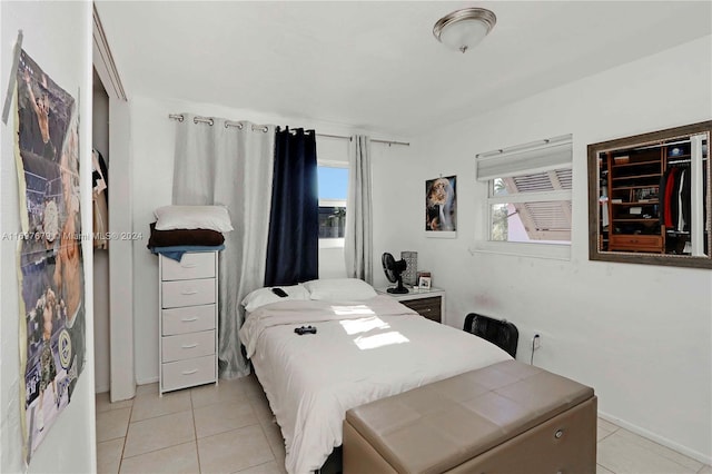 bedroom with light tile patterned floors and multiple windows