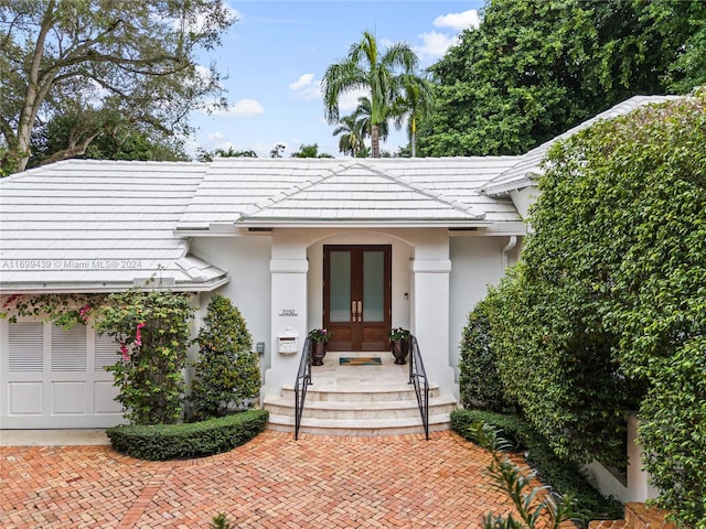 doorway to property featuring french doors and a garage