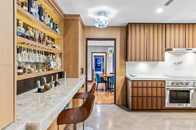 bar featuring black electric cooktop and oven