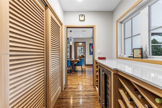 corridor with dark hardwood / wood-style floors and wine cooler