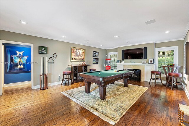 playroom featuring pool table, ornamental molding, a fireplace, and hardwood / wood-style floors