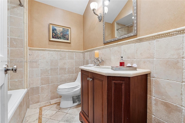 full bathroom featuring tiled shower / bath combo, vanity, tile walls, and toilet