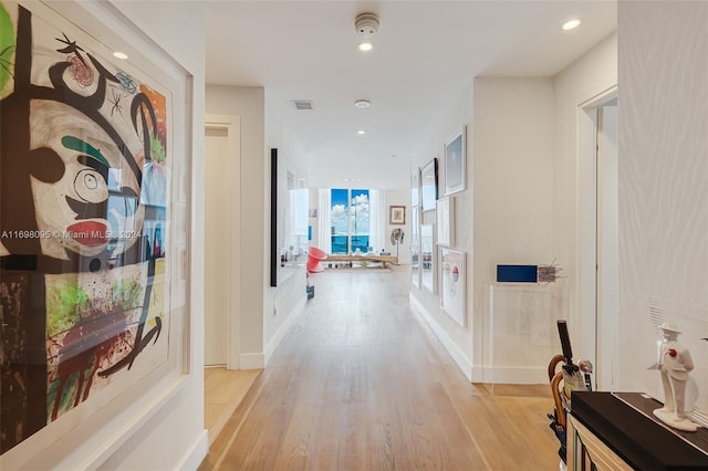 hallway with light hardwood / wood-style floors