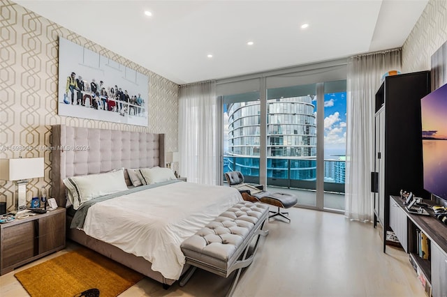 bedroom featuring a wall of windows and access to outside