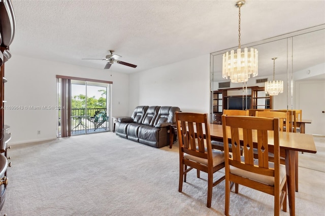 dining space featuring a textured ceiling, ceiling fan with notable chandelier, and light carpet