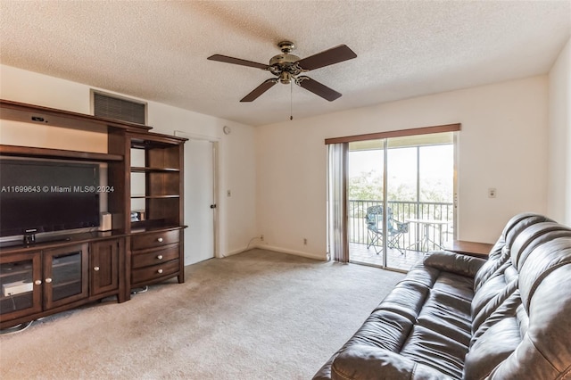 carpeted living room featuring ceiling fan and a textured ceiling