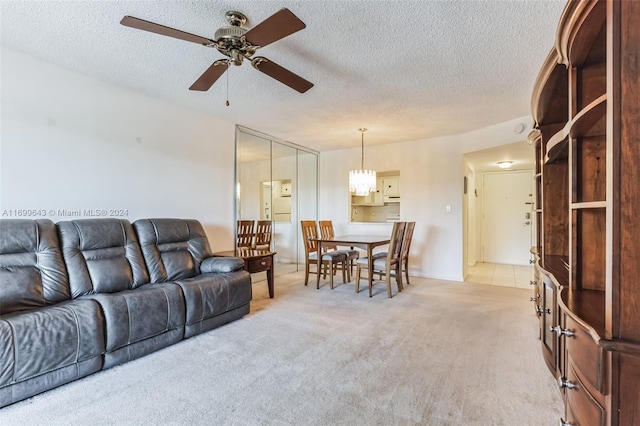 carpeted living room featuring ceiling fan and a textured ceiling