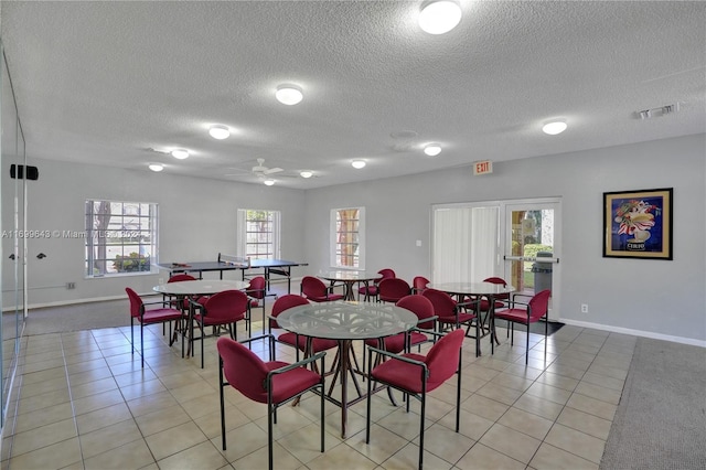 tiled dining space with ceiling fan and a textured ceiling