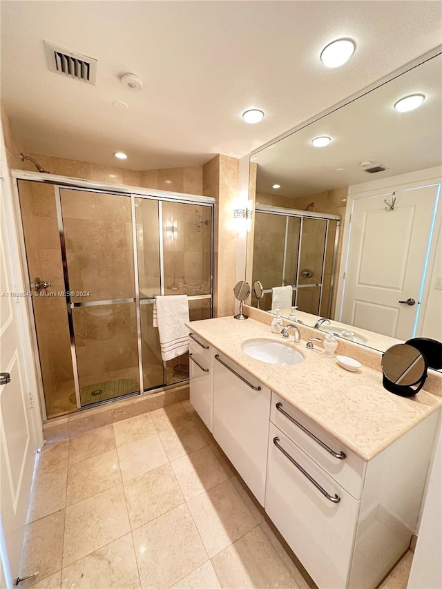 bathroom featuring tile patterned flooring, vanity, and an enclosed shower