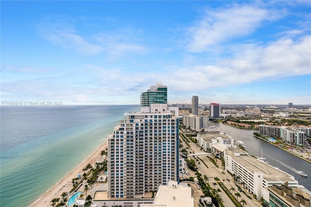 drone / aerial view featuring a water view, a view of the beach, and a city view