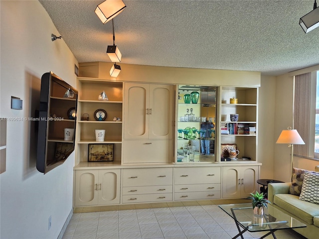 tiled living room featuring a textured ceiling