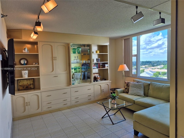 living room with light tile patterned flooring and a textured ceiling