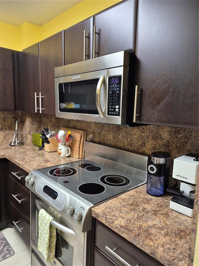 kitchen with dark brown cabinets, backsplash, stainless steel appliances, and light tile patterned floors