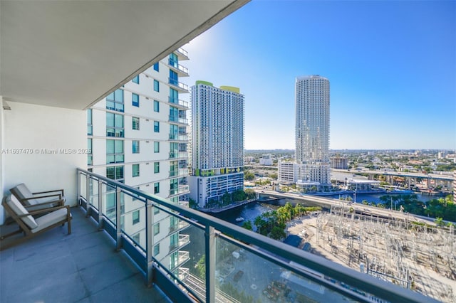 balcony featuring a water view and a city view