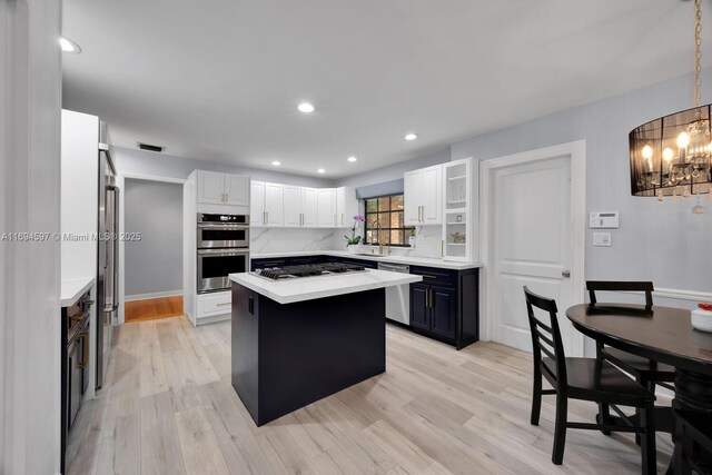 6065 SW 133rd St, Pinecrest, FL 33156 - kitchen featuring stainless steel appliances, a chandelier, light countertops, a kitchen island, and white cabinetry