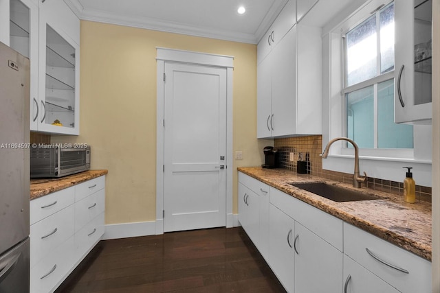 6065 SW 133rd St, Pinecrest, FL 33156 - kitchen with a sink, freestanding refrigerator, white cabinets, ornamental molding, and light stone countertops