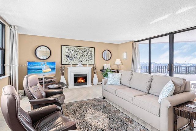 living room with light colored carpet, a wall of windows, and a textured ceiling